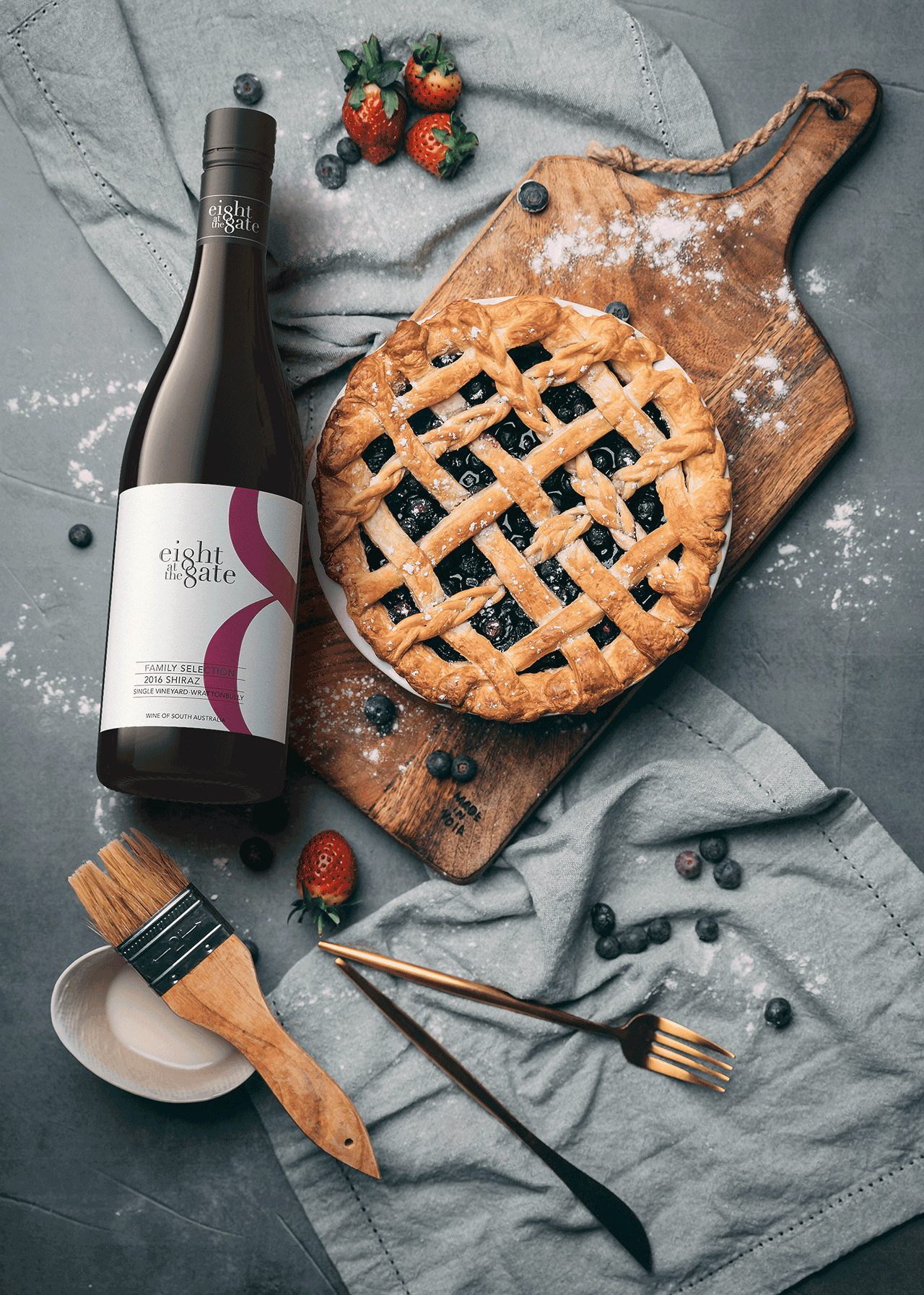 Eight at the Gate 2016 Shiraz on a table next to a blue berry pie.
